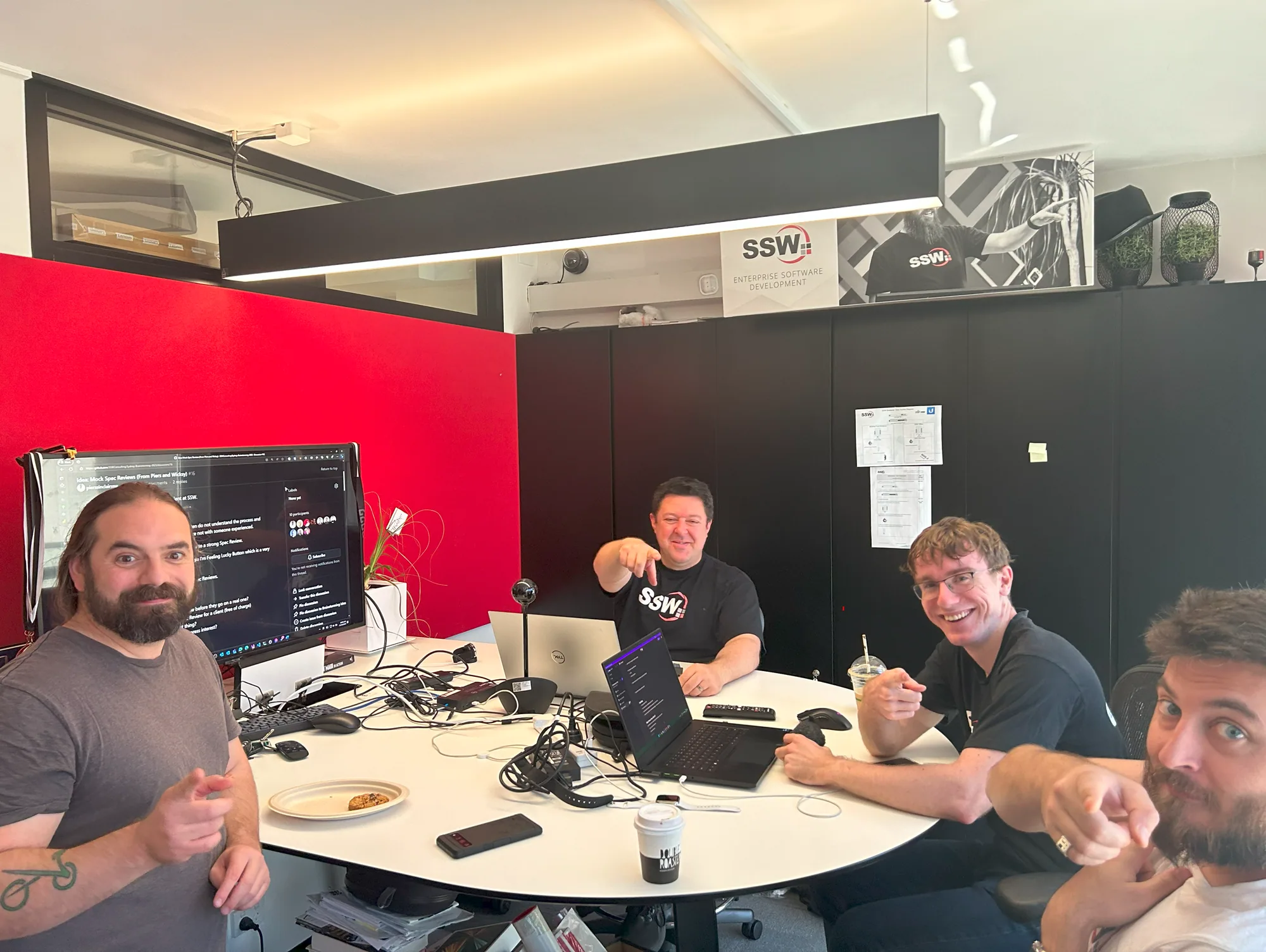 A group of brainstormers looking at the camera and pointing