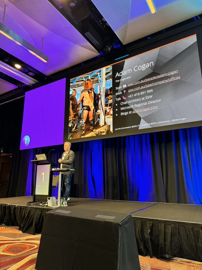 Adam Cogan presenting, slide with Viking costume